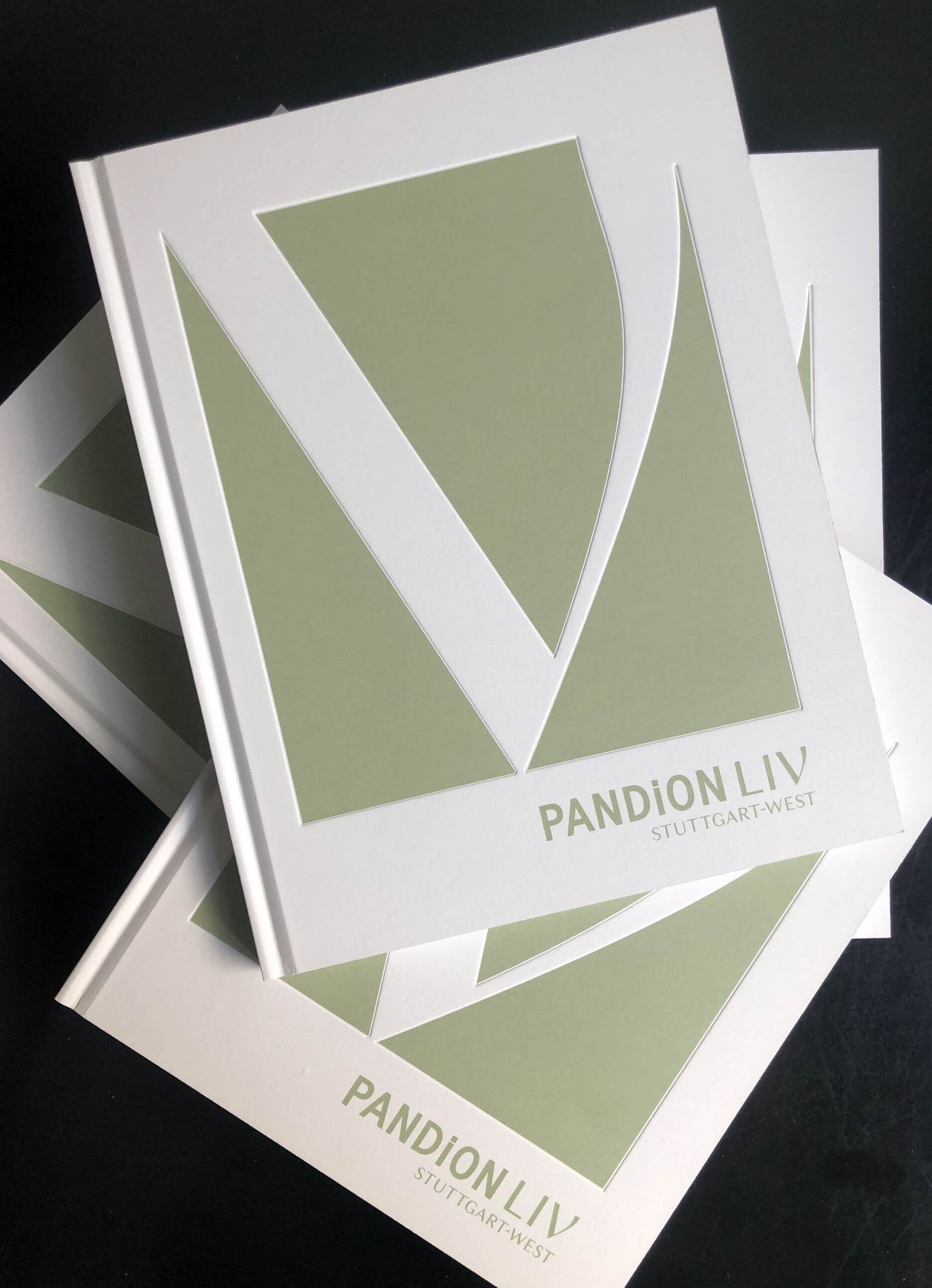 mehrere PANDION Liv Broschüren liegen ungeordnet gestapelt aufeinander