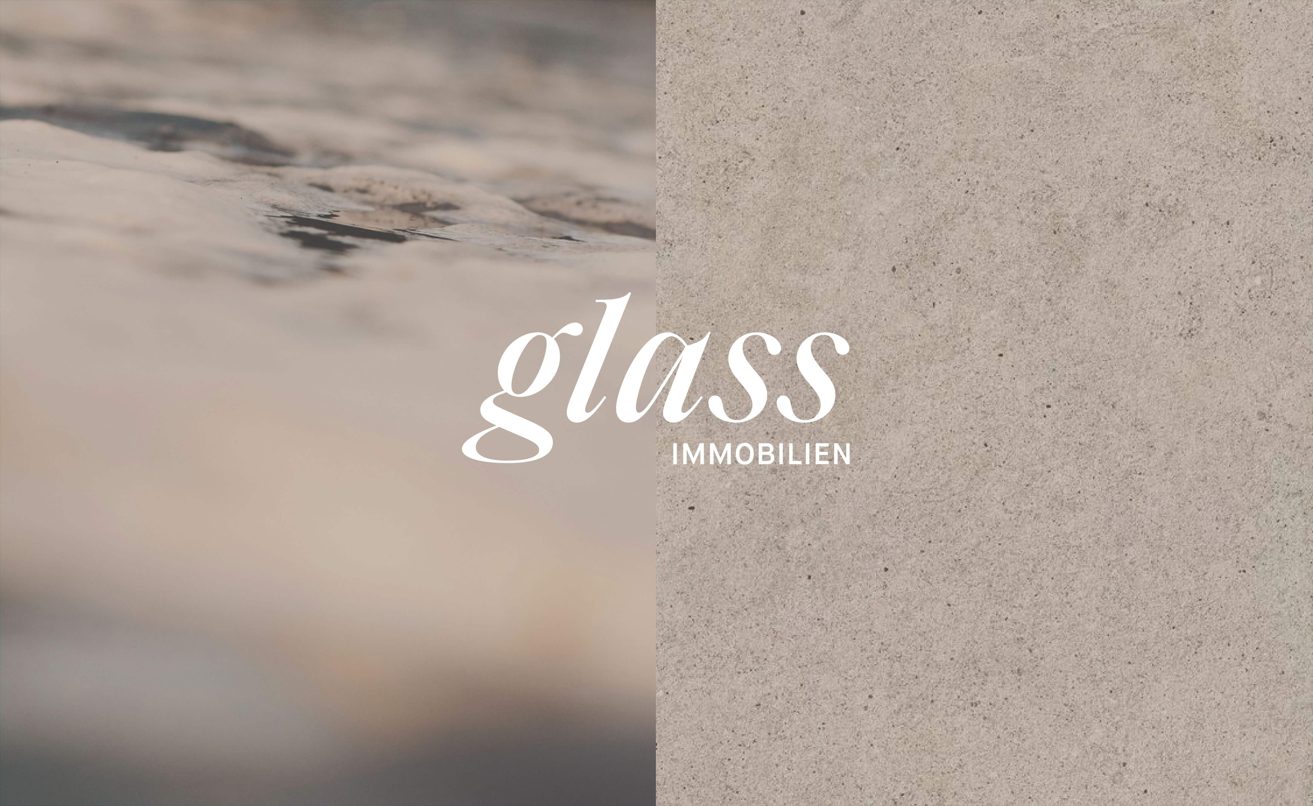 das logo von glass immobilien auf einem in zwei hälften geteilten bild. Eine Hälfte zeigt ein offenes Gewässer in einer Nahaufnahme, die rechte Seite zeigt eine steinige Struktur.