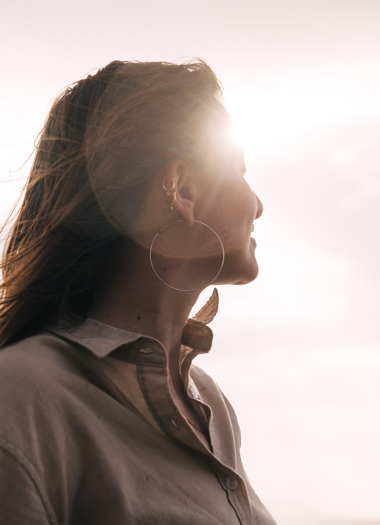 Eine Frau schaut in die Ferne mit Sonnenlicht